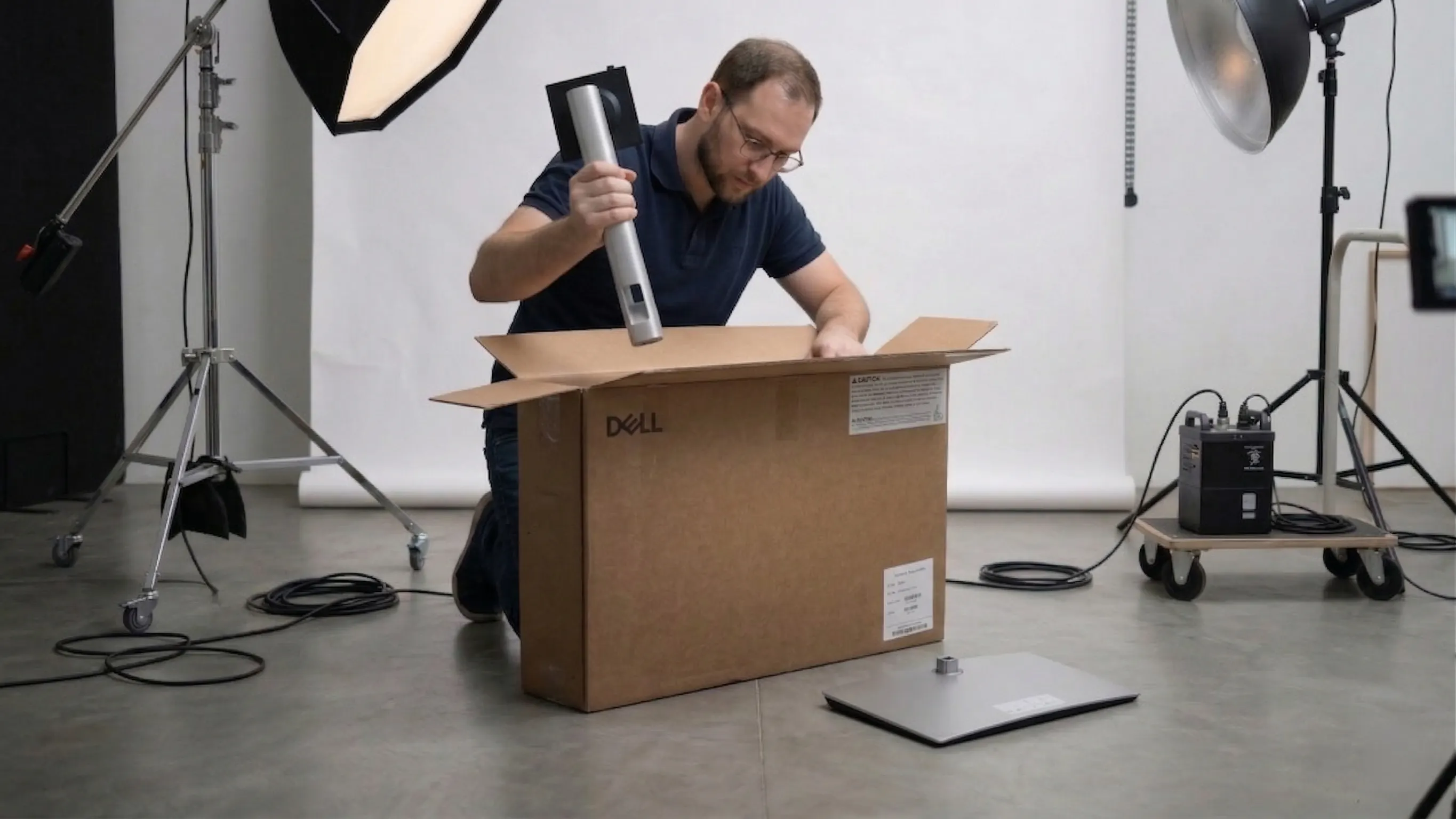 Arkadiusz wyjmuje metalową nogę (podstawę) Dell Pro 24 z kartonu